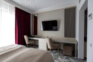 a bedroom with a desk and a tv on a wall at CHITULESCU Hotel in Târgovişte