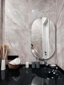 a bathroom with a sink and a mirror at Комфорт сити in Almaty +39 photos