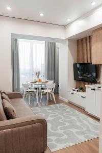 a living room with a couch and a table at Комфорт сити in Almaty