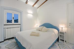 una camera da letto bianca con un letto grande e una finestra di Anciüetta a Lerici