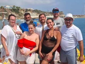 a group of people posing for a picture on a boat at Poseidon boat trips in Svoronata