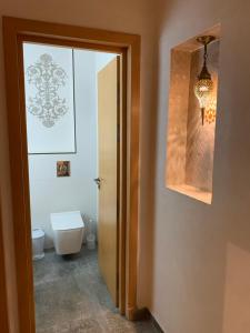 a bathroom with a toilet and a window and a door at The Little Royal Mansour 2 in Agadir +17 photos