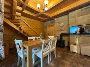 una sala da pranzo con un tavolo e una tv di Willa z Bala 1 - z sauną i balią a Miedzybrodzie Żywieckie
