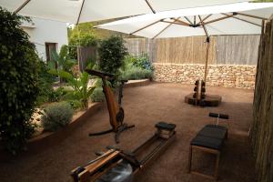 a patio with an umbrella and a treadmill at Mar Suites Formentera by Universal Beach Hotels in Es Pujols
