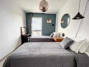 Un dormitorio con dos camas y una ventana. en Villa Escale Marine, Vue Mer, 3 chambres - 2 lits double et 2 lits simples, en La Ciotat
