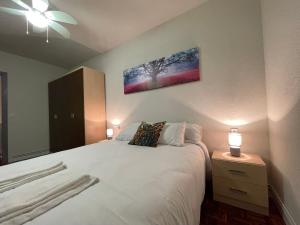 a bedroom with a large white bed with two lamps at Terracita de Gayarre in Tudela