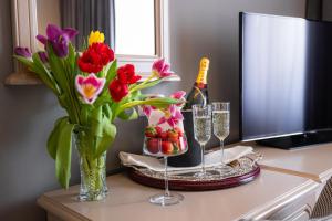 a table with flowers and a bottle of champagne and glasses at Hotel Brilliant Meseș in Zalău