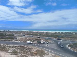 Una autopista con coches en ella con el océano en Muizenberg Magic OceanfrontOasis, en Marina da Gama