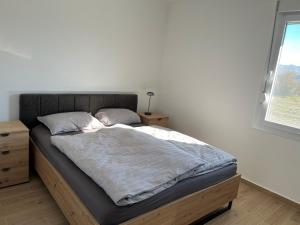 a bedroom with a bed with a wooden frame and a window at Montenegro Grahovo hideaway in Nikšić