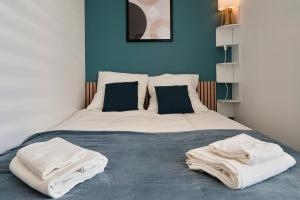 a bedroom with a bed with towels on it at Le Brother - Les Demeures d 'Adrien in Carvin