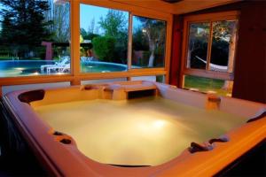 a large bath tub in a room with a pool at Robles de Besares in Chacras de Coria