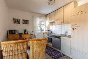 a kitchen with wooden cabinets and a sink and chairs at Lovely Rita, Appartement Kaprun in Kaprun