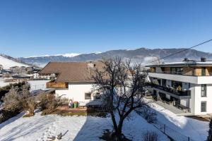a house in the snow with a tree at Lovely Rita, Appartement Kaprun in Kaprun