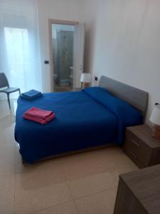 a bedroom with a blue bed with a red towel on it at Poesia di Lerici in Lerici