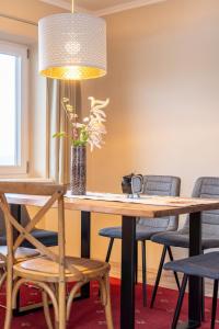 a wooden table with chairs and a vase with flowers at Family Apartment Deluxe Mutters in Innsbruck +8 photos