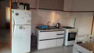 a kitchen with white appliances and a white refrigerator at Cabaña la Tijereta del Iporá in Balneario Ipora +5 photos
