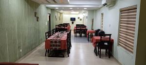 a restaurant with tables and chairs with red table cloth at CLUB 99 SUITES in Kakkanad