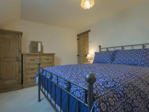 a bedroom with a blue bed and a dresser at Moorhaven in Okehampton