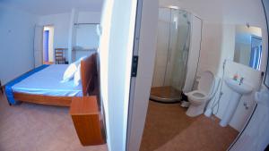 una camera da letto con un letto, una doccia e un bagno di Cacimba Sunset Lodge a Tarrafal