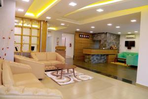 a living room with couches and a table and a fireplace at CLUB 99 SUITES in Kakkanad