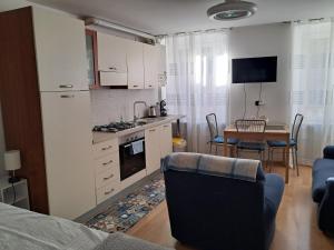 a kitchen and living room with a table and a couch at Monolocale Paola in Rovereto