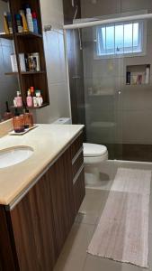 Un baño con lavabo, inodoro y ducha. en Casa Familiar, en São Gabriel