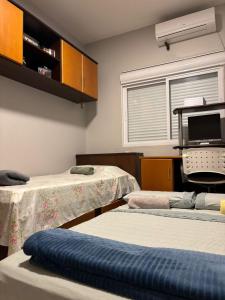 Una habitación de hospital con dos camas y un monitor. en Casa Familiar, en São Gabriel