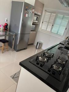 una cocina con estufa y refrigerador en Casa Familiar, en São Gabriel
