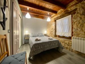 a bedroom with a bed and a stone wall at La Mambla de la Ribera in Mambrilla de Castrejón