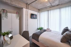 a bedroom with a bed and a large window at Central Warrington Stay Stylish 1BR Apartment in Warrington