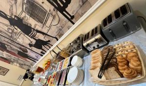 a counter with a tray of bread and pastries at Chelsea House Hotel - B&B in London