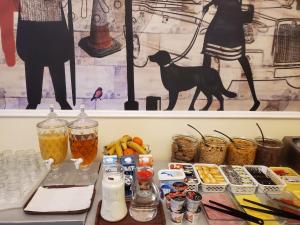 a table with drinks and a black dog on a wall at Chelsea House Hotel - B&B in London +30 photos