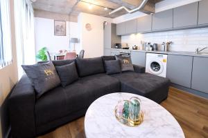 a living room with a black couch and a table at Modern Living 1Bed in Central Warrington in Warrington +11 photos