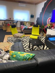a living room with a couch and two yellow chairs at The Workmans Palace in Jelgava