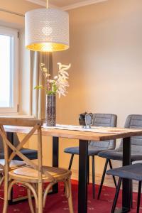 una mesa de madera con sillas y un jarrón con flores en Family Apartment Deluxe Mutters, en Innsbruck
