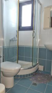 a bathroom with a shower with a toilet and a sink at Coastal maisonette in Nea Potidaea