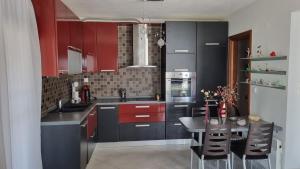 a kitchen with red cabinets and a table in it at Coastal maisonette in Nea Potidaea
