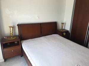a bedroom with a bed and two nightstands with two vases at Coastal maisonette in Nea Potidaea