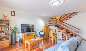 Una sala de estar con un sofá y un comedor. en Casa da Abegoaria, en Caniço