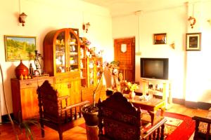 a living room with a television and a table and chairs at Mansarover Home Stay in Kalimpong