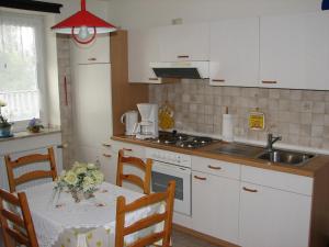 a kitchen with a table and a sink at Ferienwohnungen Langholz in Hohn
