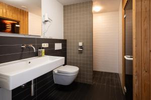 a bathroom with a white sink and a toilet at Appartementenhotel Tjermelân Terschelling in Oosterend +70 photos