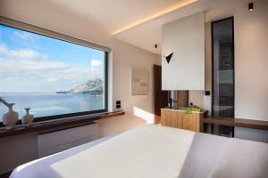 a bedroom with a large window with a view of the ocean at Rokkea Villa in Plakias