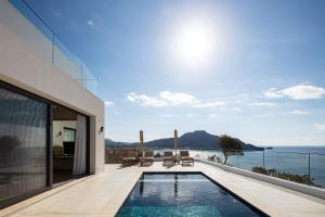 a house with a swimming pool and a view of the ocean at Rokkea Villa in Plakias