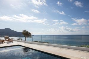 a swimming pool with a view of the ocean at Rokkea Villa in Plakias