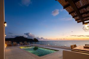 a villa with a swimming pool and a view of the ocean at Rokkea Villa in Plakias