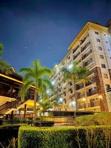 a large building with palm trees in front of it at AJs One Oasis 1 bedroom in Cagayan de Oro