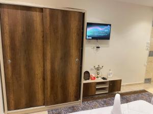 a large wooden door in a room with a tv at Sunrise Family Big Room in Cairo