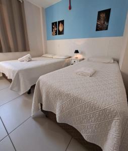 two beds in a room with blue walls at Gravata Hotel frente mar in Navegantes
