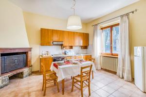 Una cocina con una mesa con sillas y una estufa. en Homes Boccaccio Beautiful Terrace - Happy Rentals, en Montespertoli